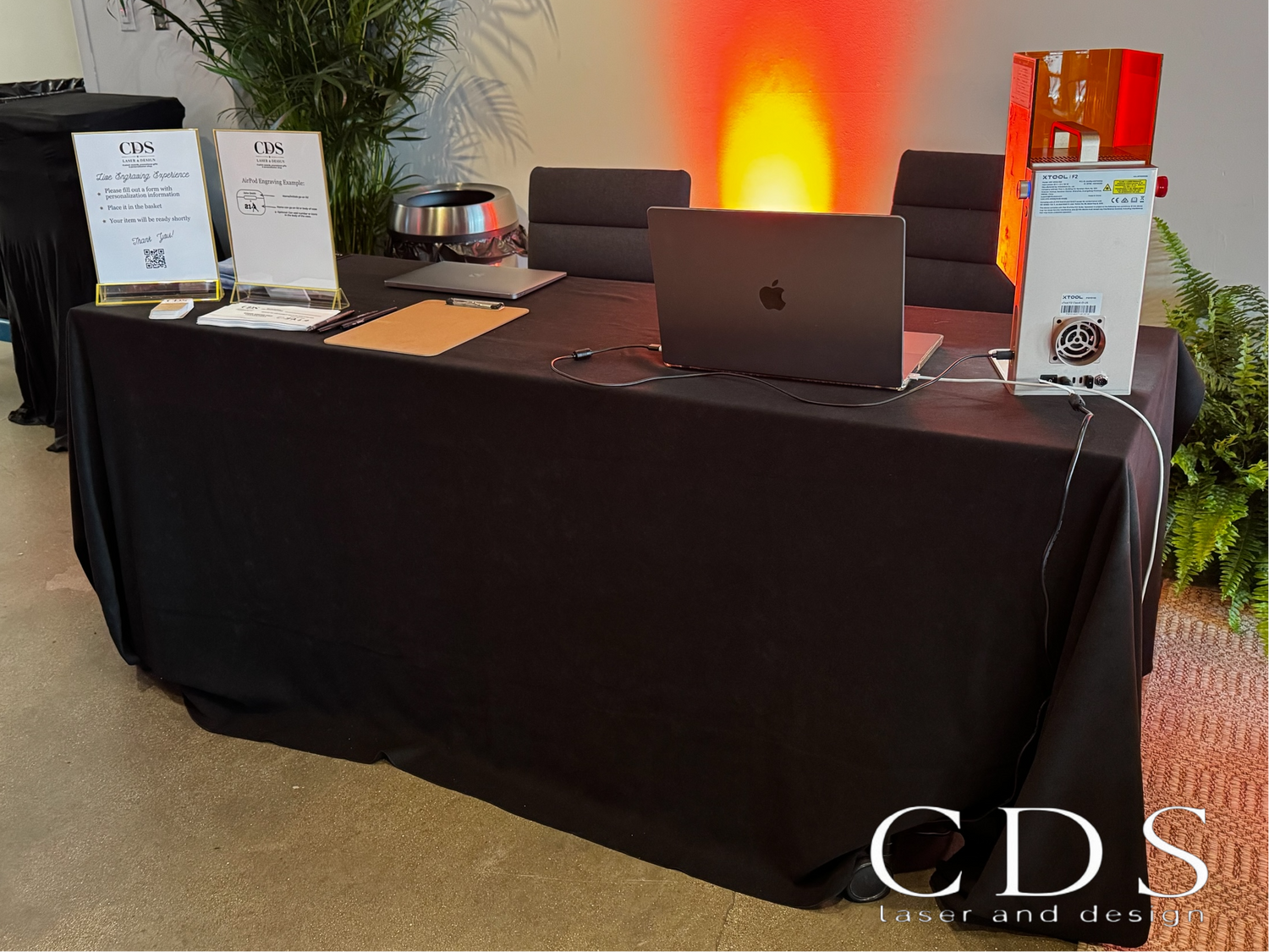 Table with laptop, CDS branding, and decorative elements in a room setting