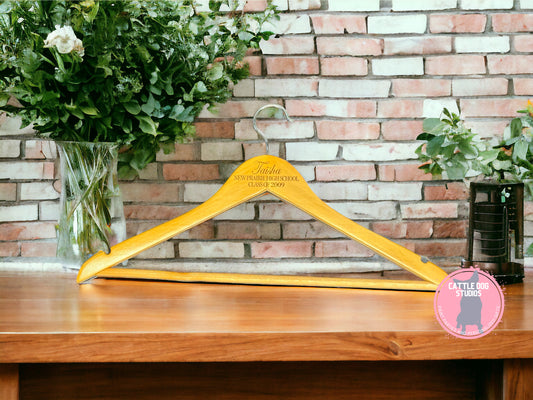 Natural wood clothes hanger engraved with the graduate's name and class year